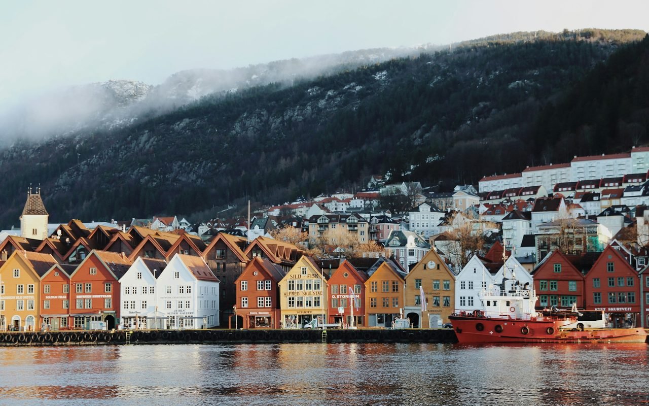 The Bryggen wharf in Bergen beneath a misty mountainside